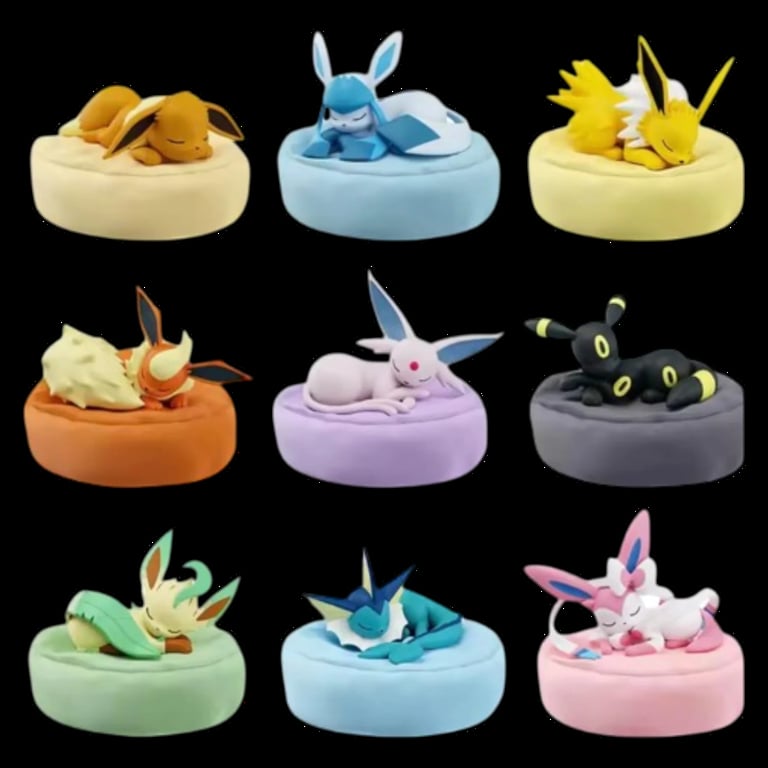 Grid of nine Pokémon plush toys in colorful beds, featuring characters like Eevee, Pikachu, Mareep, and others on cushioned platforms